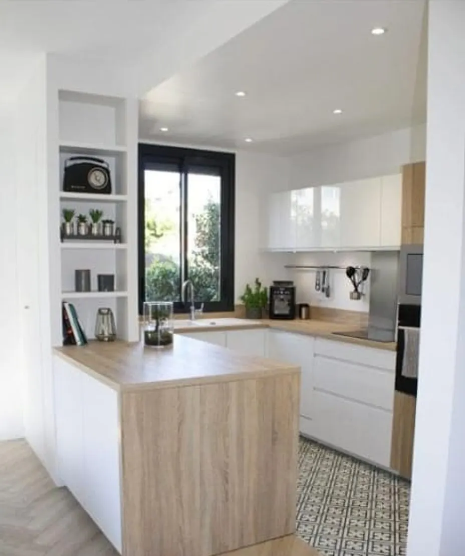 Cuisine après rénovation — meubles blancs, plan de travail bois, carreaux de ciment