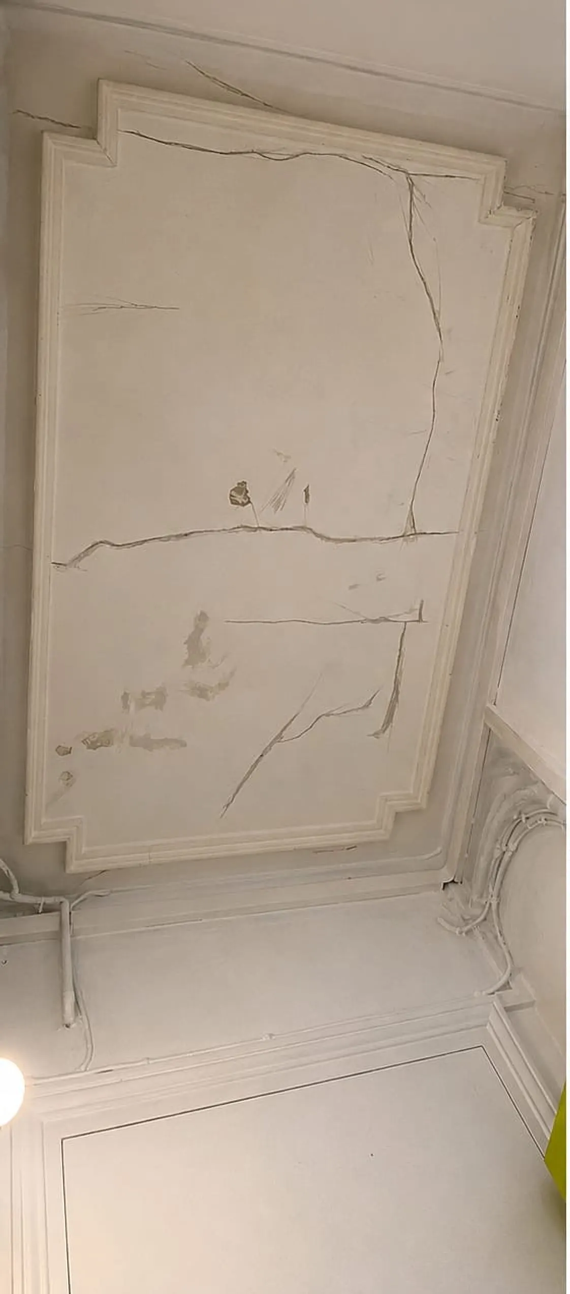 Moulures haussmanniennes avant restauration — plâtre fissuré et éclats